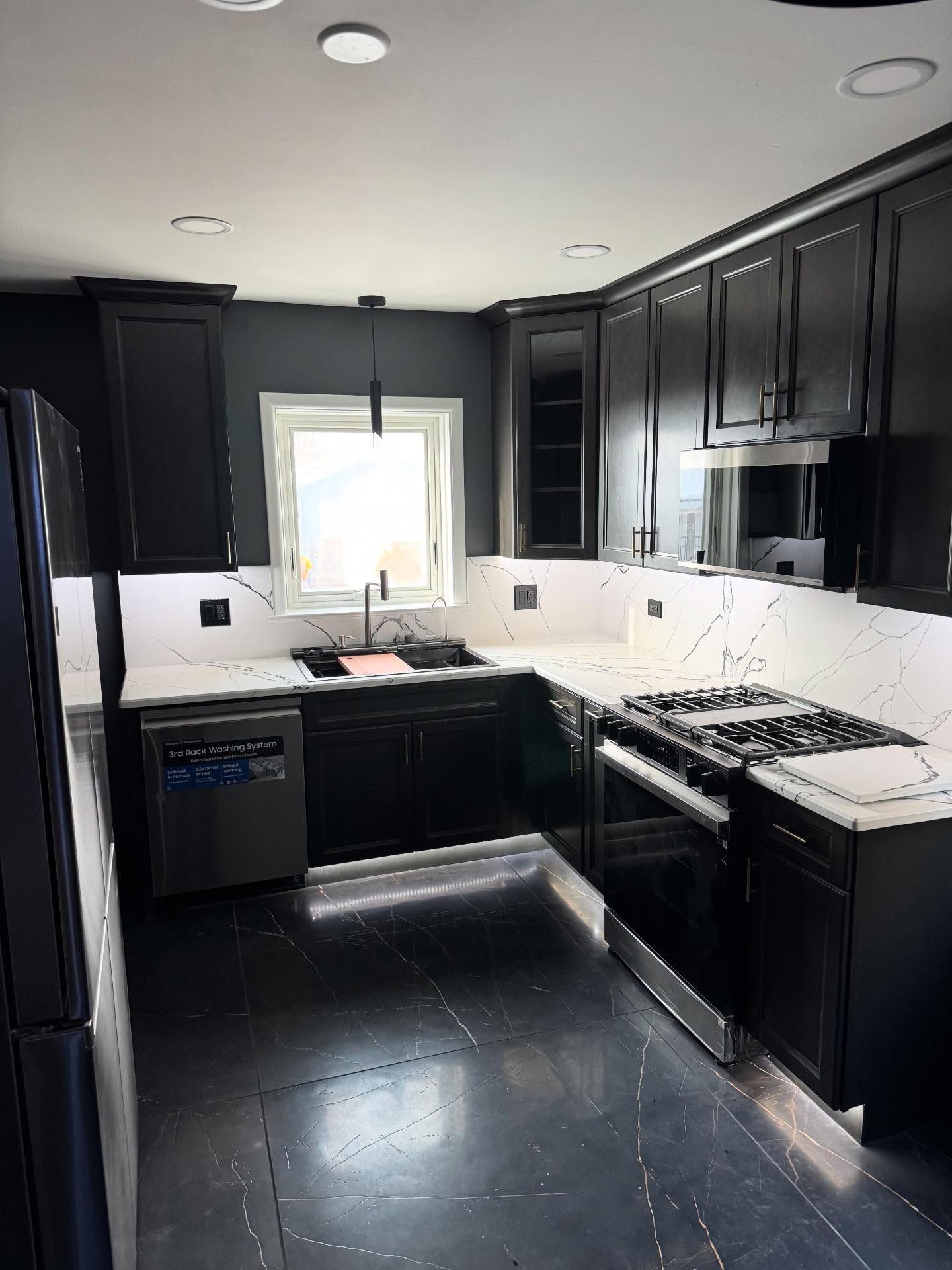Black kitchen remodel with quartz countertops by ADR Construction