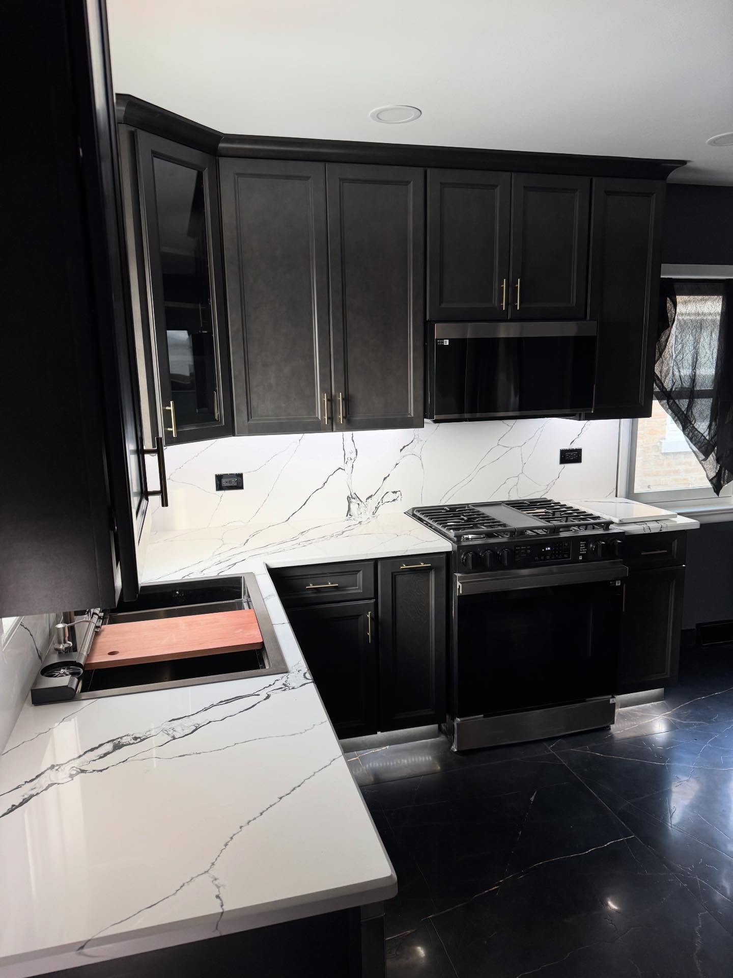 Black kitchen remodel with range wall and quartz counters by ADR Construction
