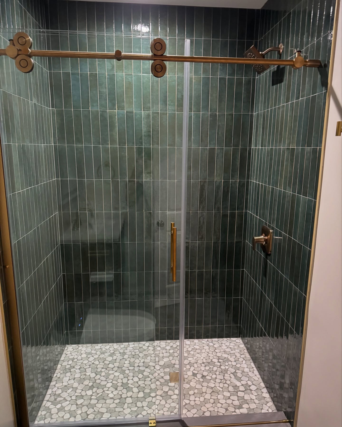 Luxury green tile shower with gold hardware by ADR Construction
