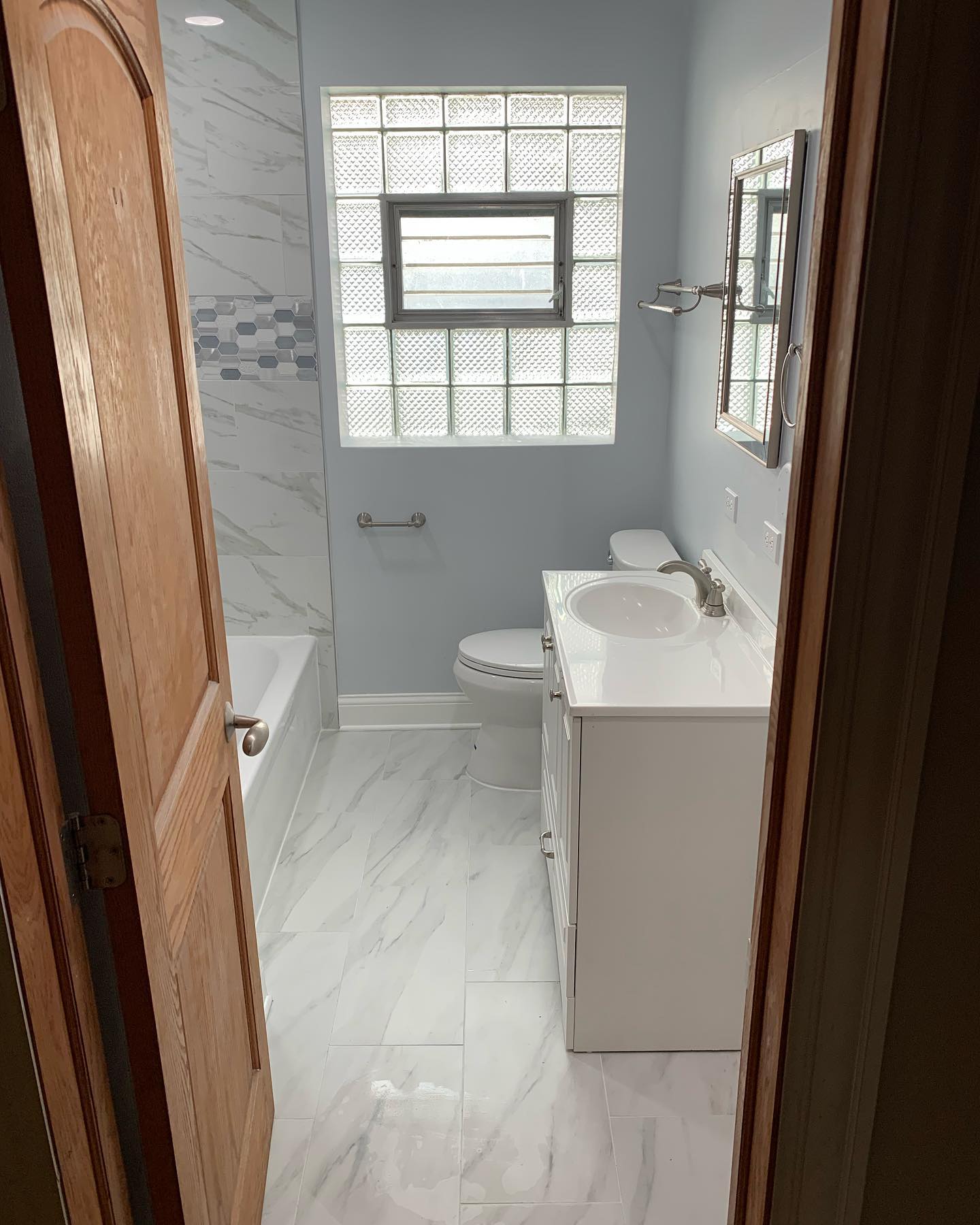 Complete bathroom renovation with marble-look porcelain by ADR Construction