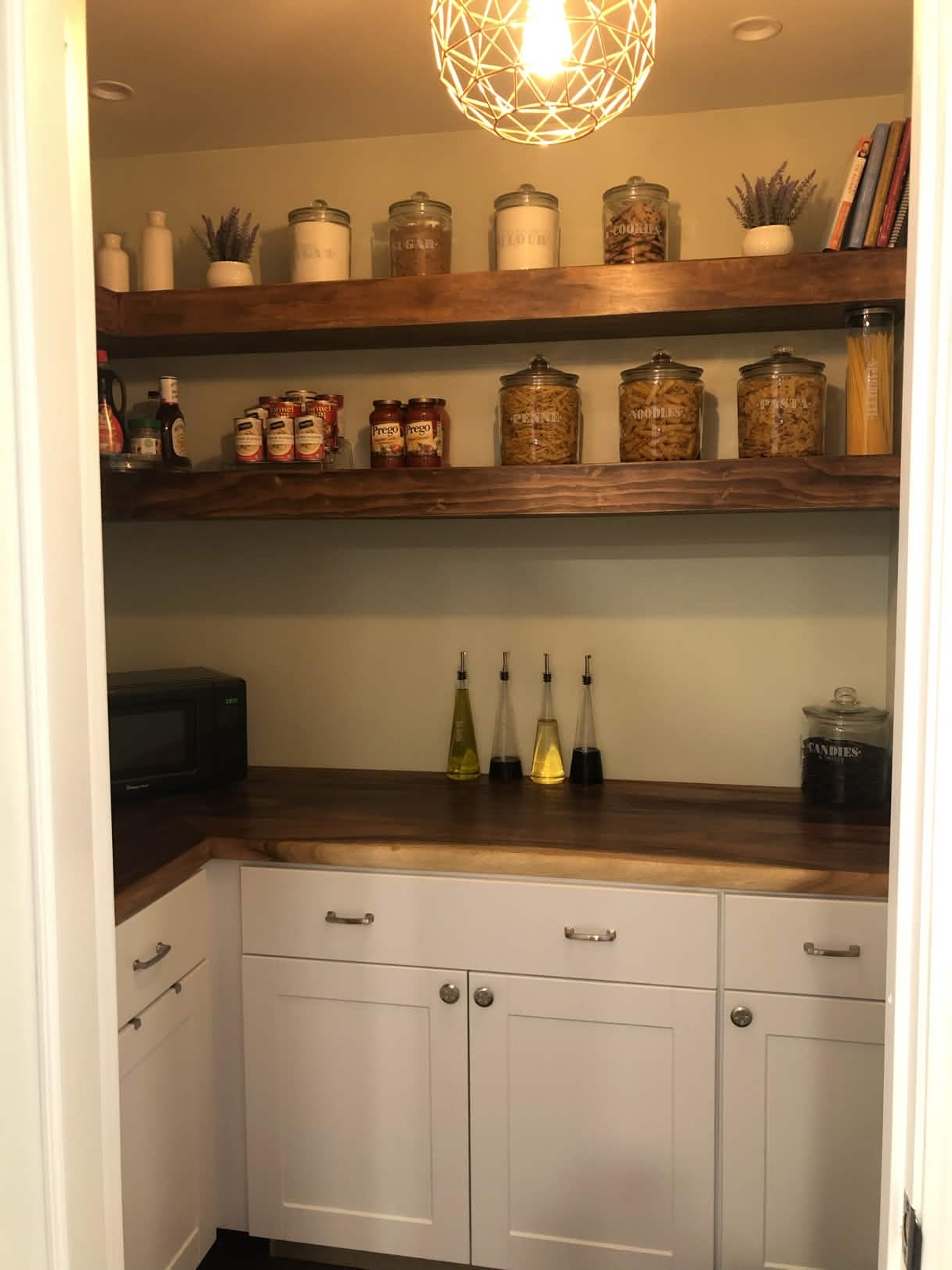 Custom pantry built-in with white cabinets and wood shelves by ADR Construction
