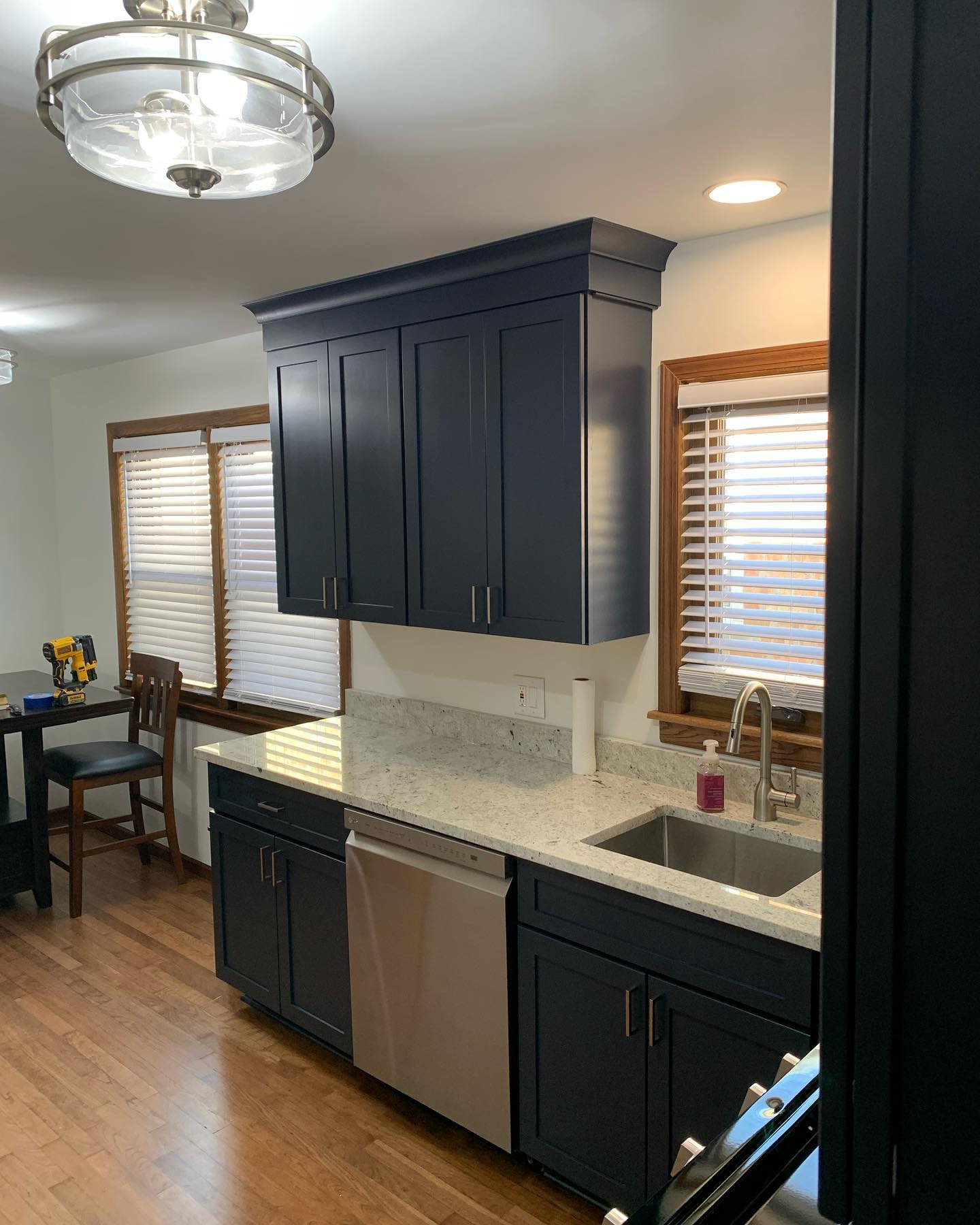 Kitchen finished with navy cabinets and marble