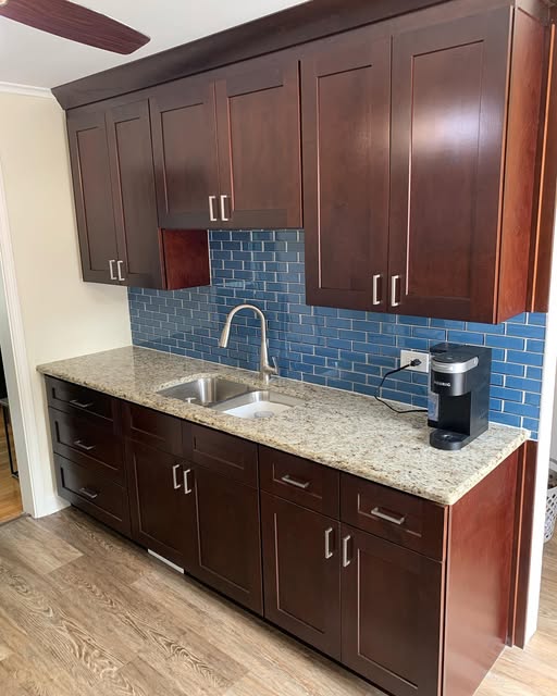 Cherry wood kitchen with blue tile backsplash by ADR Construction